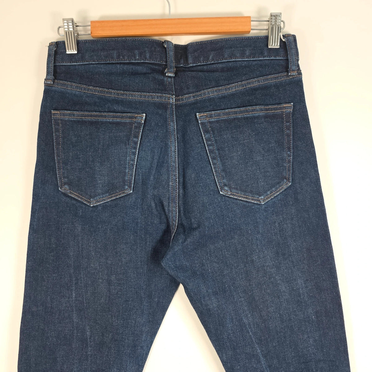 UNIQLO dark indigo slim straight jeans with selvedge detailing and stretch denim material.