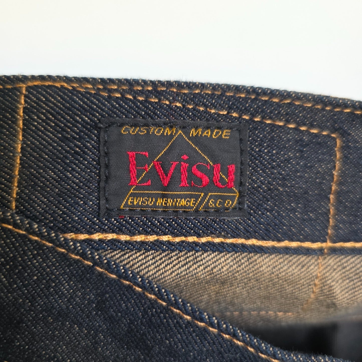 Evisu blue straight jeans with selvedge denim and button fly detailing.