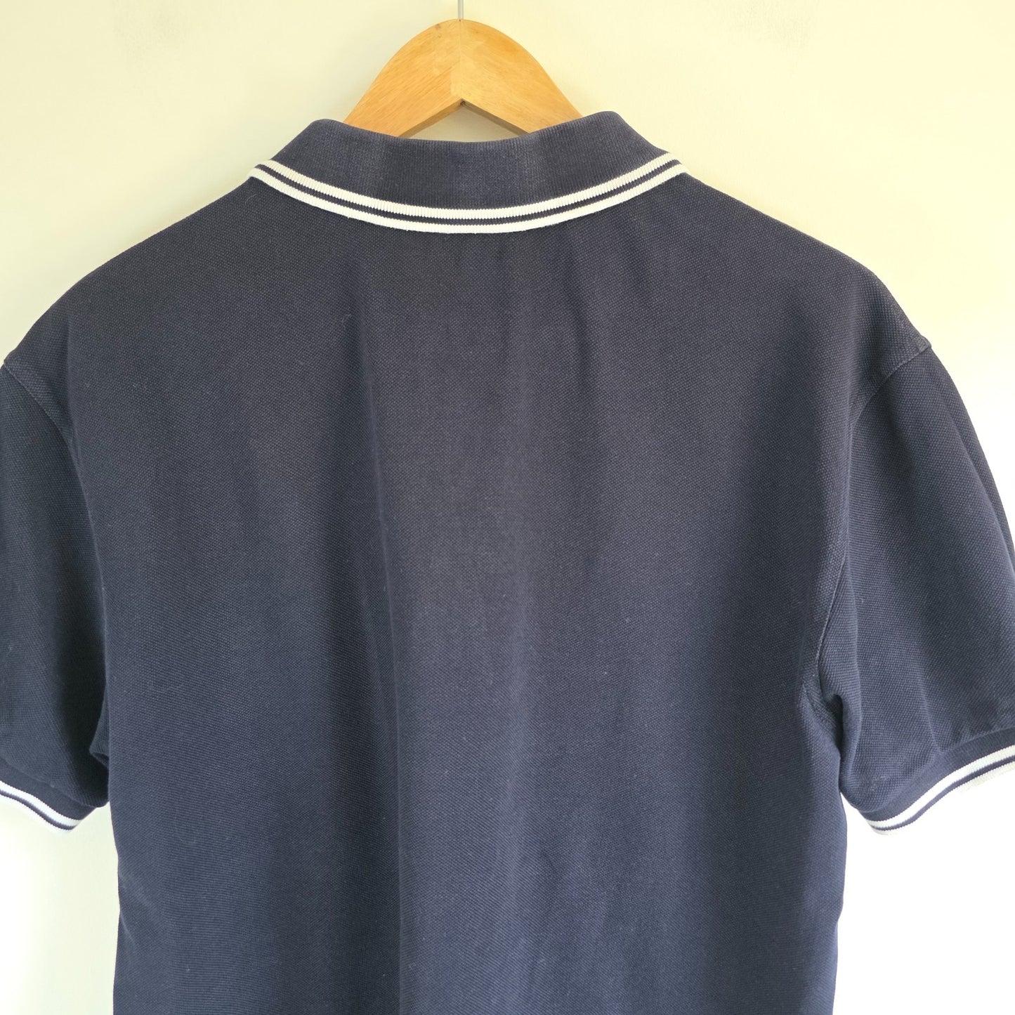 Fred Perry navy blue polo shirt with twin tipped collar and cotton material.