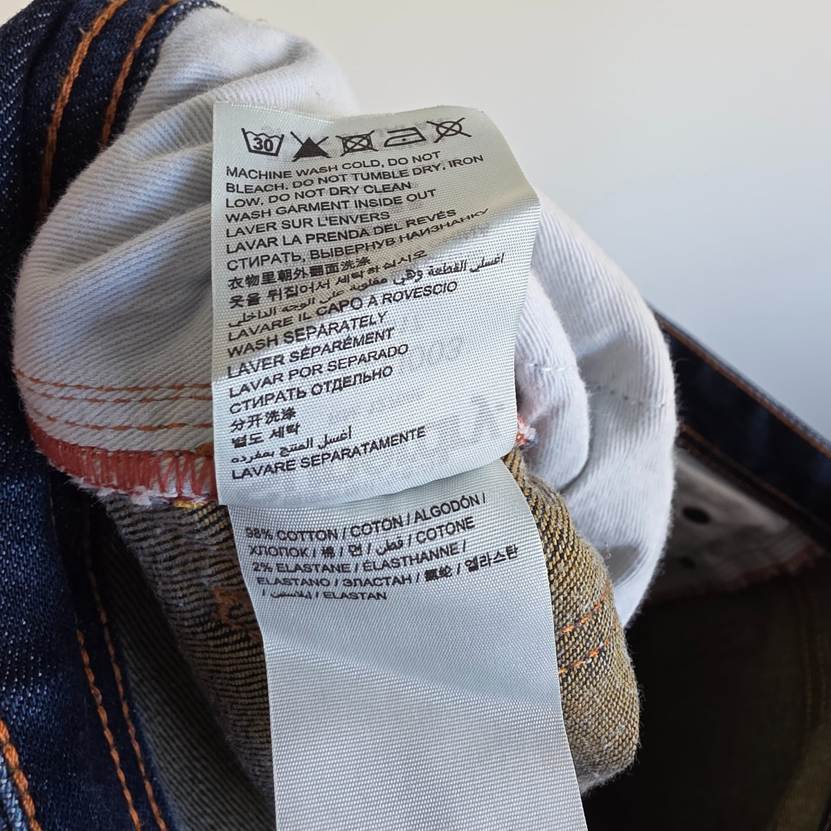 Superdry blue slim jeans with subtle fading, contrast orange stitching, and five-pocket design.