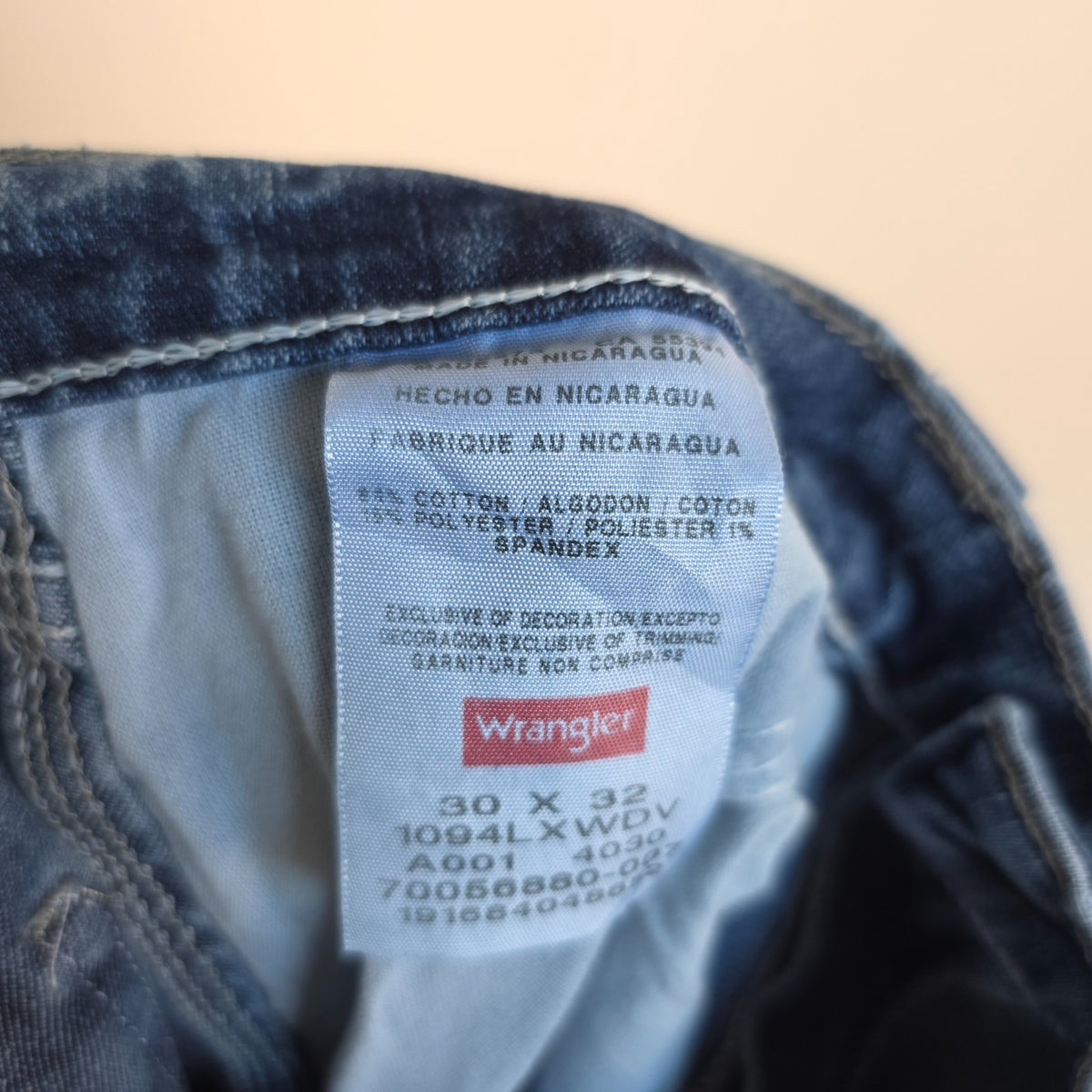 Wrangler blue carpenter jeans with distressed detailing, utility pockets, and hammer loop.