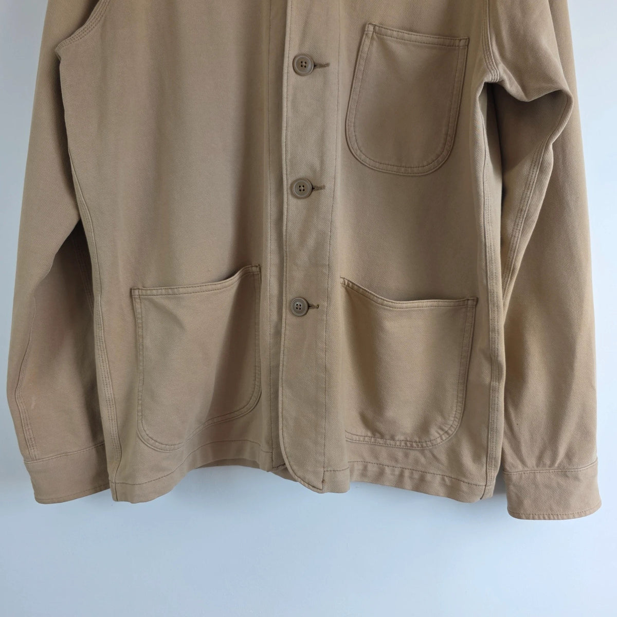 Uniqlo beige chore jacket with three patch pockets and button fastening, cotton stretch fabric.