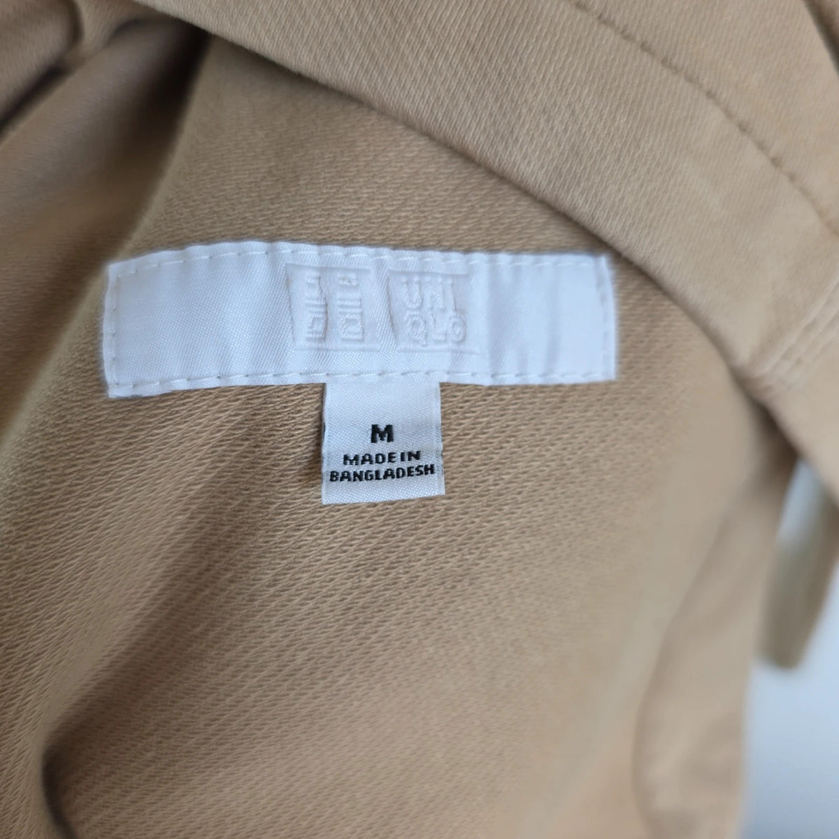 Uniqlo beige chore jacket with three patch pockets and button fastening, cotton stretch fabric.