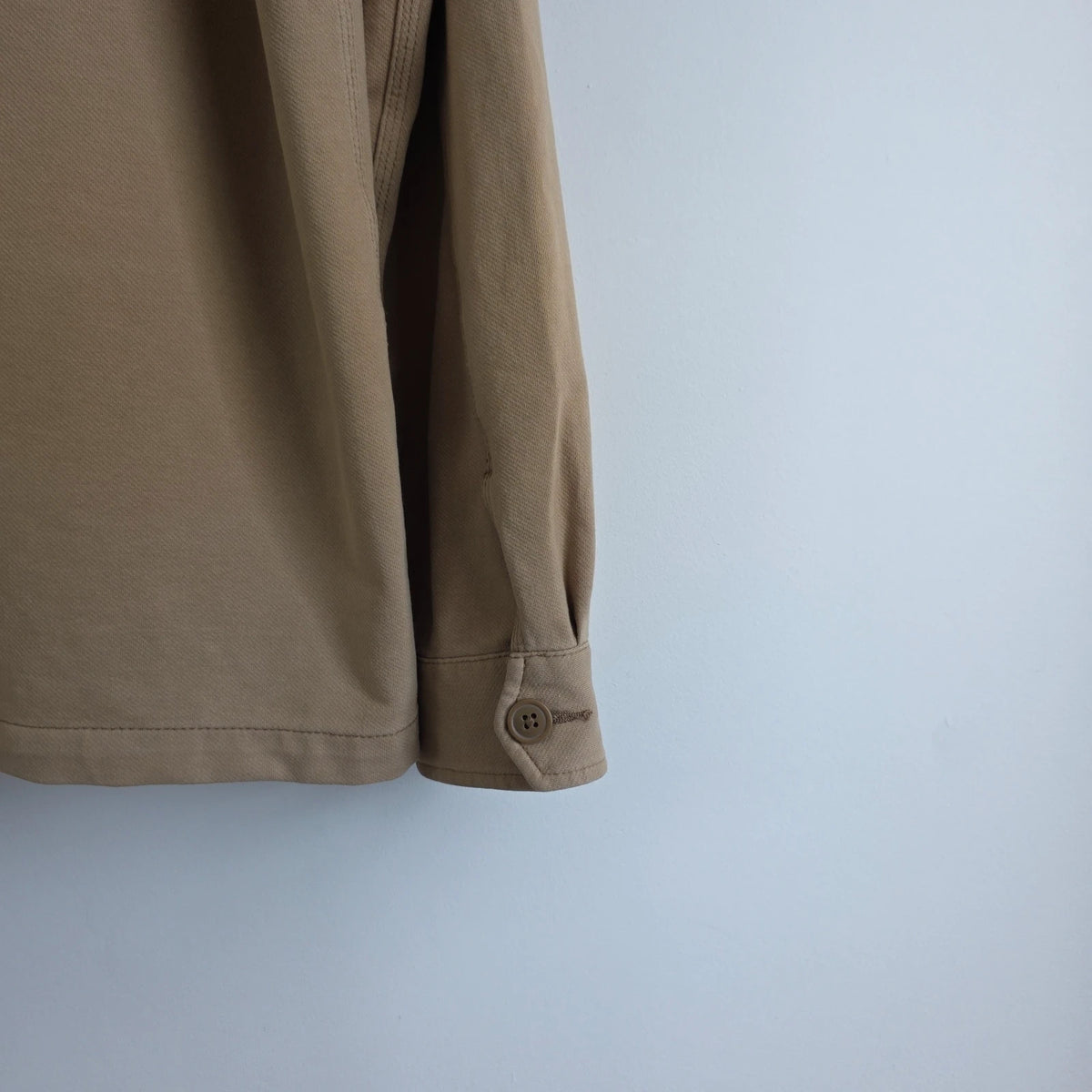 Uniqlo beige chore jacket with three patch pockets and button fastening, cotton stretch fabric.