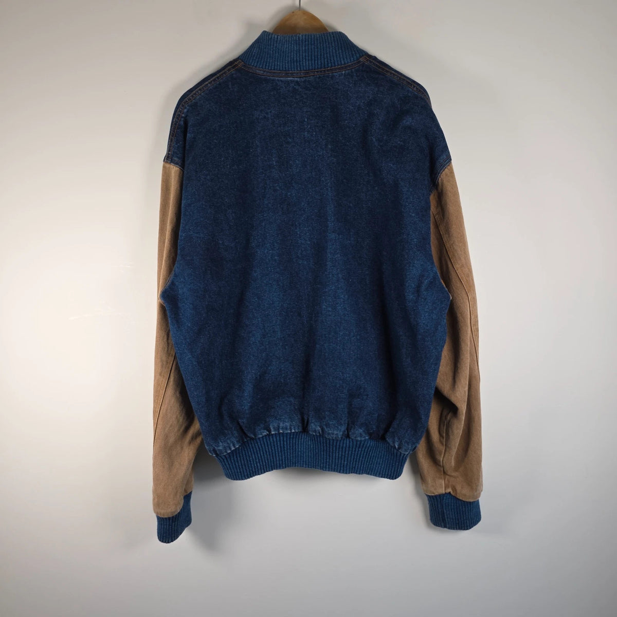 M&M's blue denim varsity bomber jacket with embroidered characters and tan sleeves.
