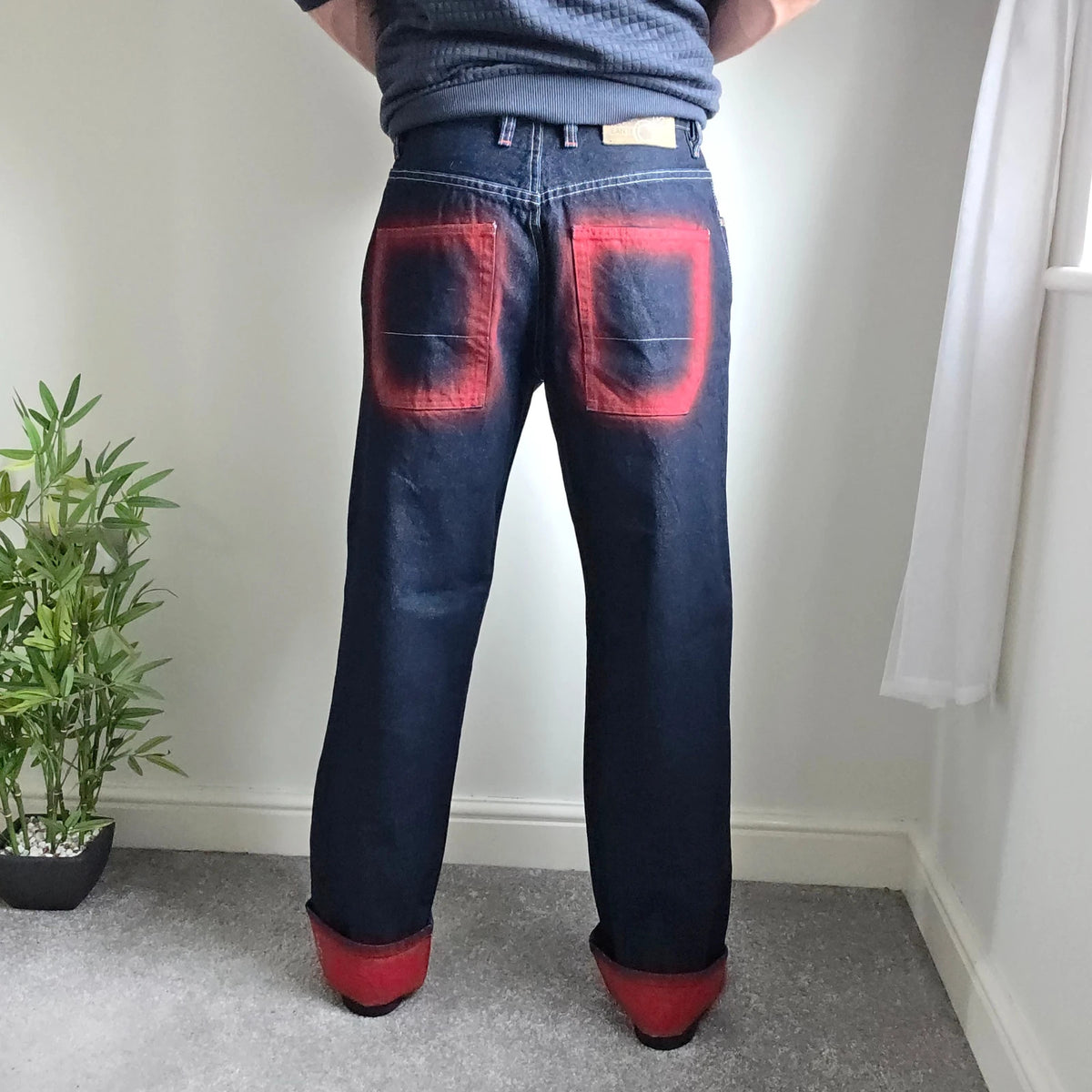 Mecca navy straight jeans with hand-painted red pockets and contrasting cuffs.