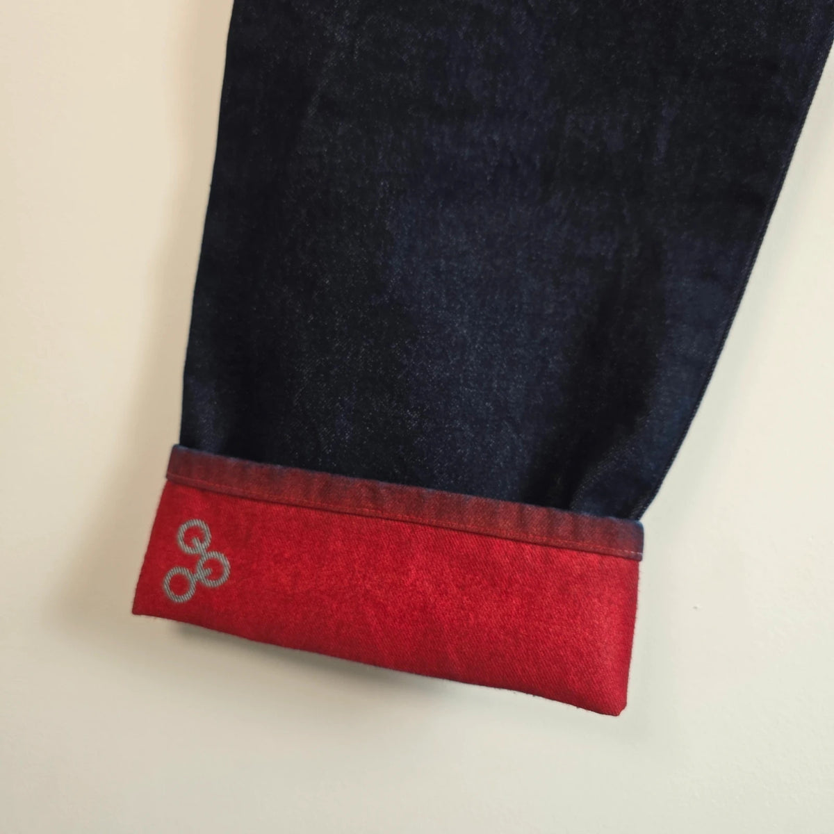Mecca navy straight jeans with hand-painted red pockets and contrasting cuffs.