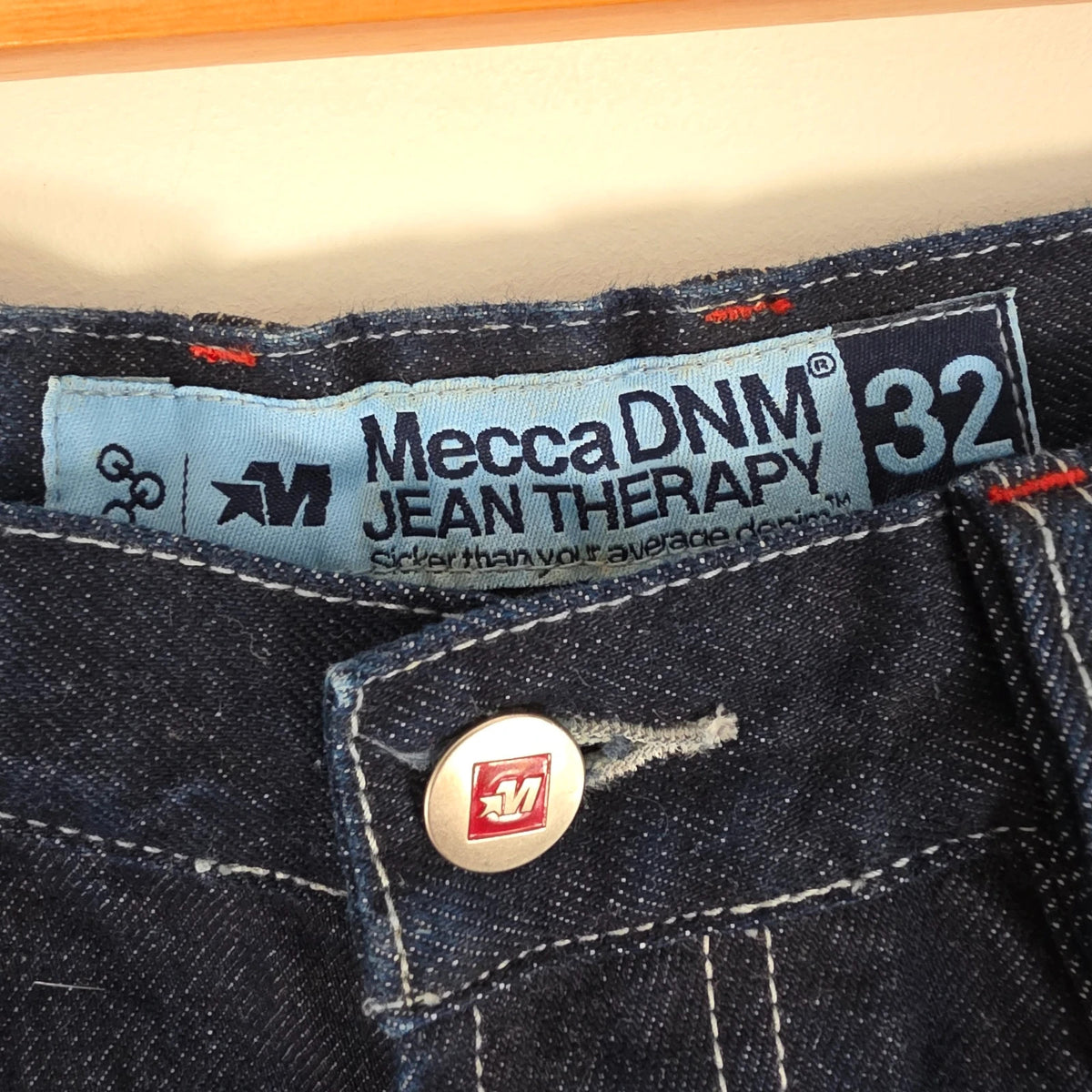 Mecca navy straight jeans with hand-painted red pockets and contrasting cuffs.