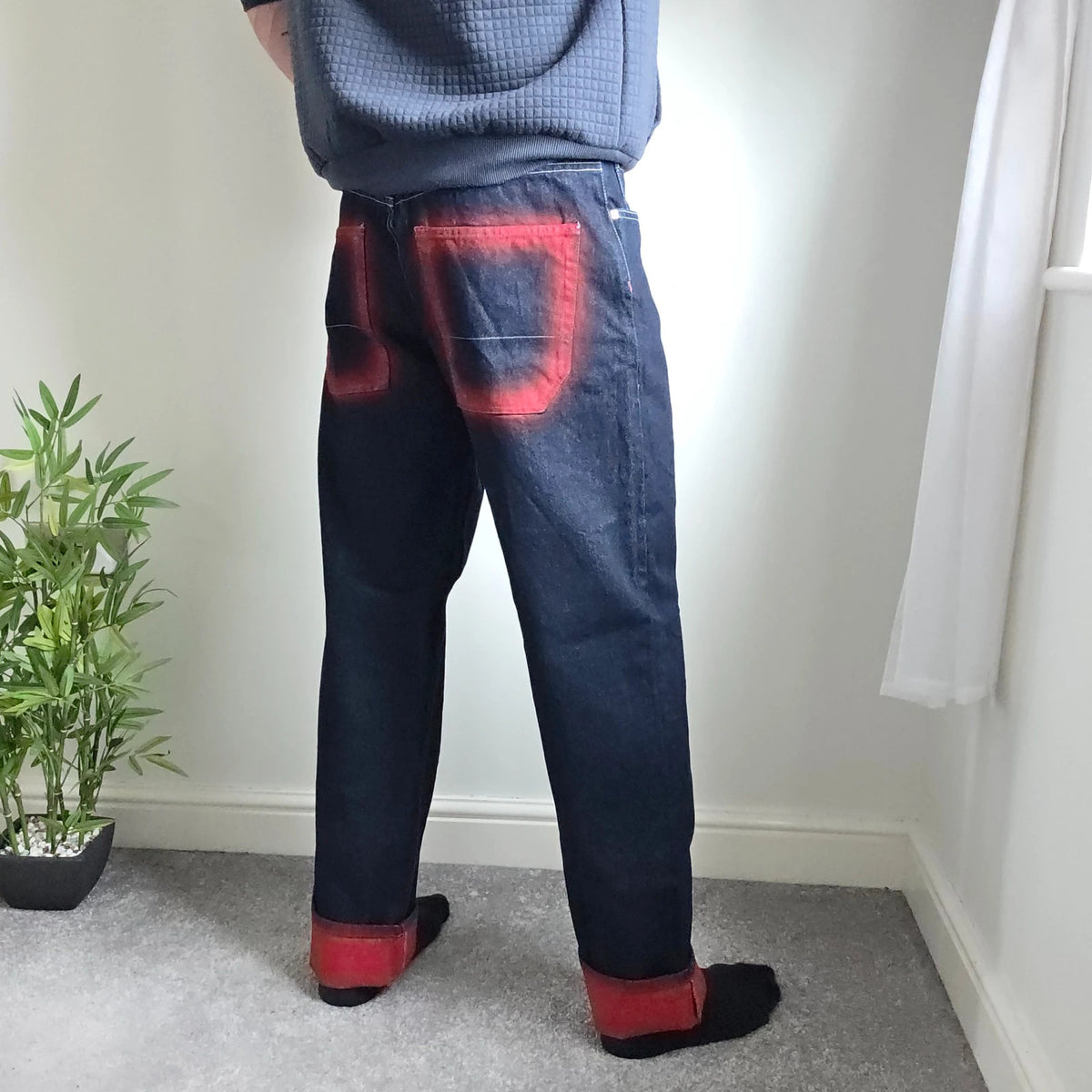 Mecca navy straight jeans with hand-painted red pockets and contrasting cuffs.