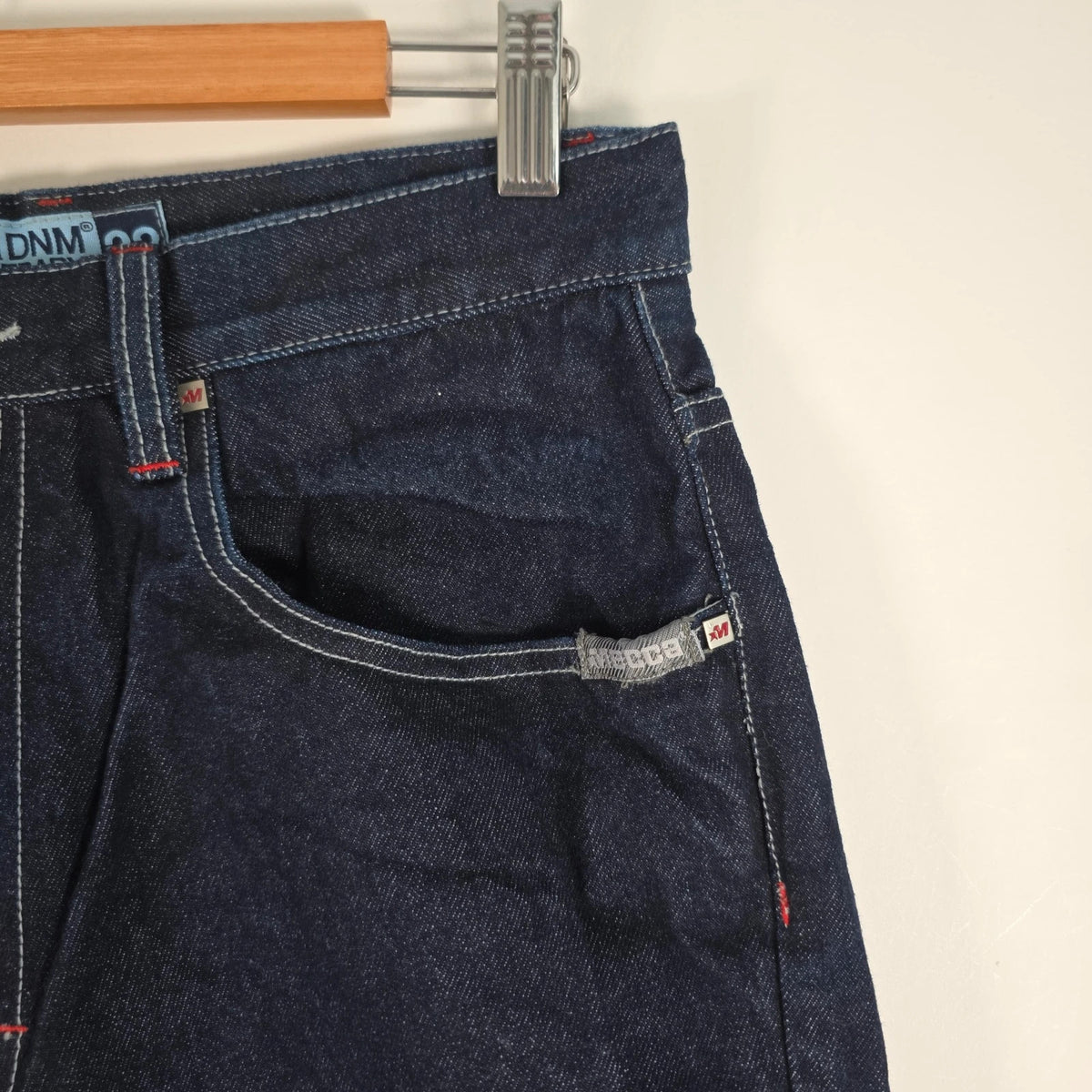 Mecca navy straight jeans with hand-painted red pockets and contrasting cuffs.