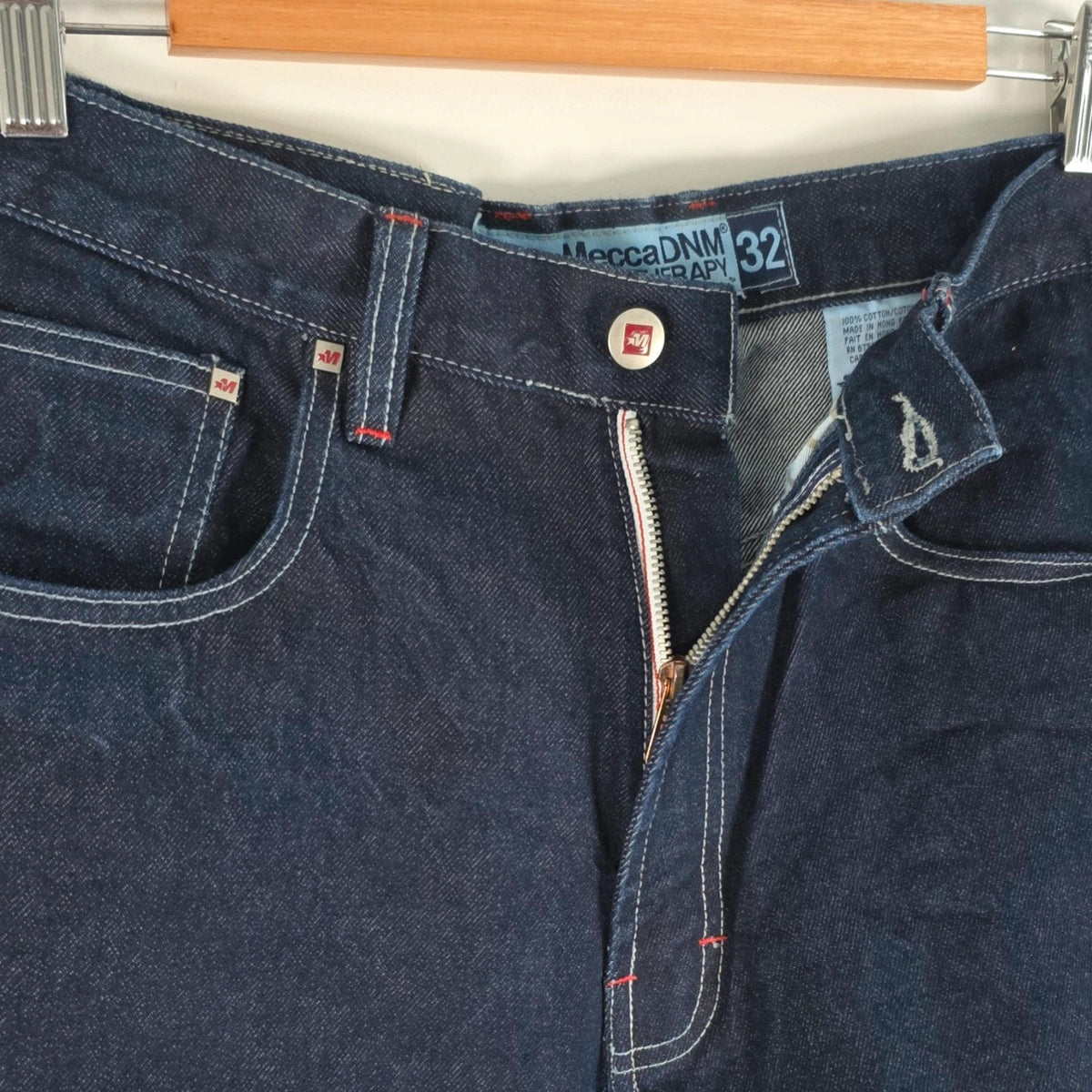 Mecca navy straight jeans with hand-painted red pockets and contrasting cuffs.