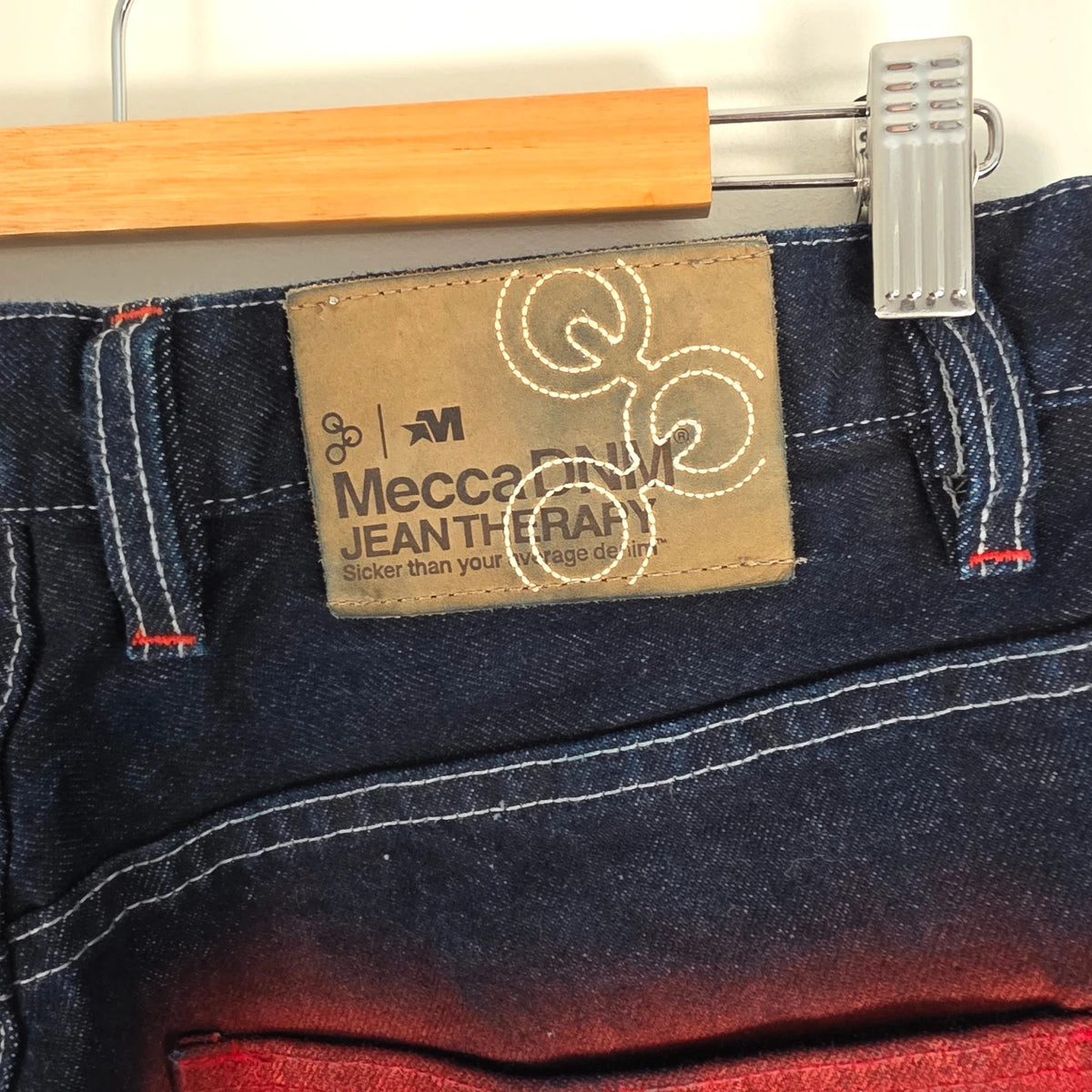 Mecca navy straight jeans with hand-painted red pockets and contrasting cuffs.