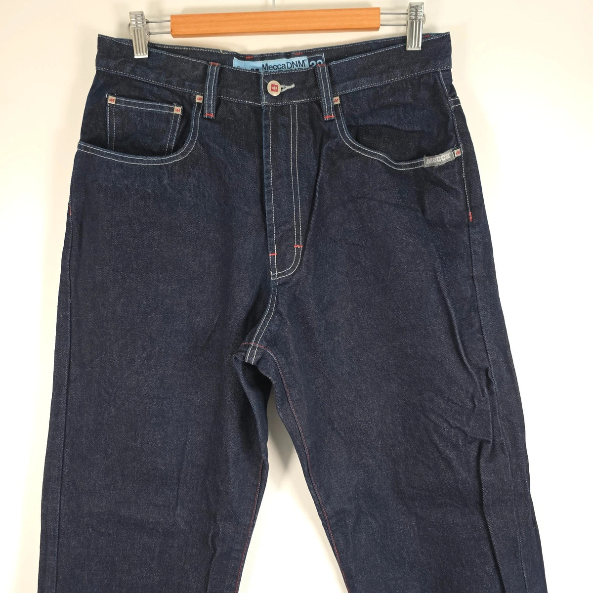 Mecca navy straight jeans with hand-painted red pockets and contrasting cuffs.
