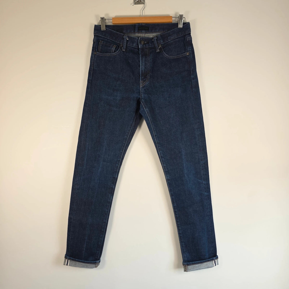UNIQLO dark indigo slim straight jeans with selvedge detailing and stretch denim material.