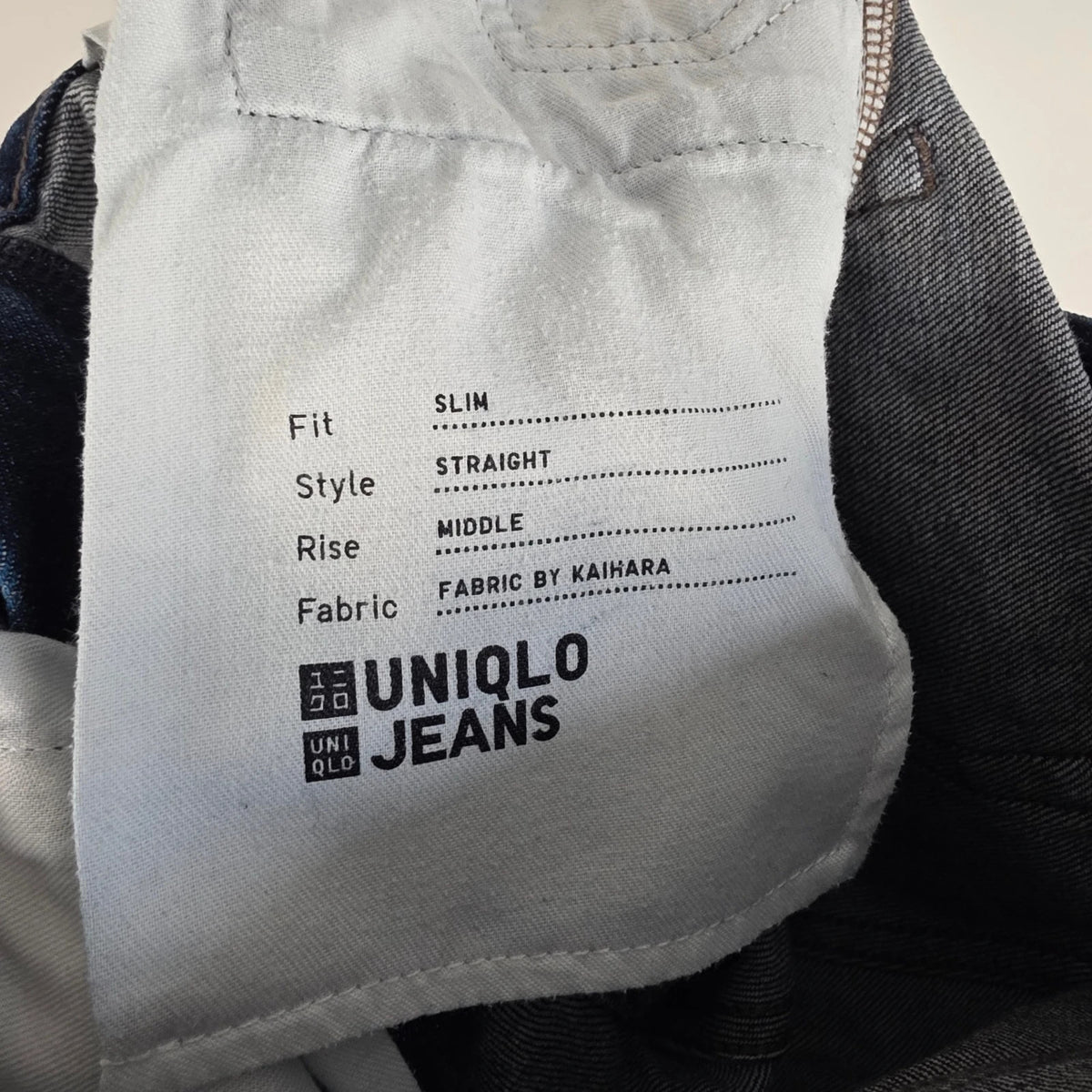 UNIQLO dark indigo slim straight jeans with selvedge detailing and stretch denim material.