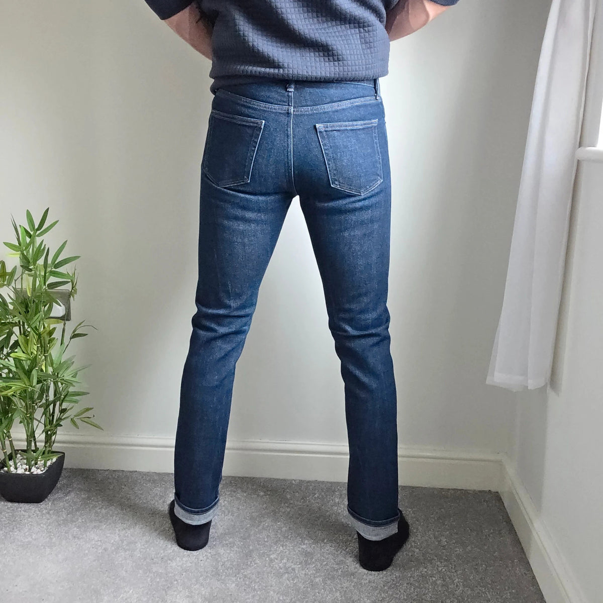 UNIQLO dark indigo slim straight jeans with selvedge detailing and stretch denim material.