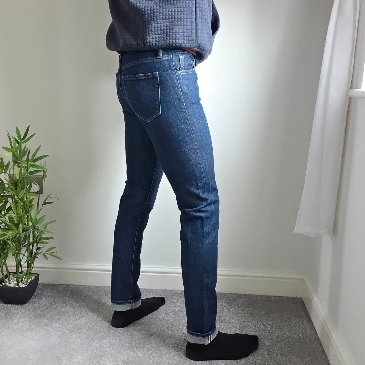 UNIQLO dark indigo slim straight jeans with selvedge detailing and stretch denim material.