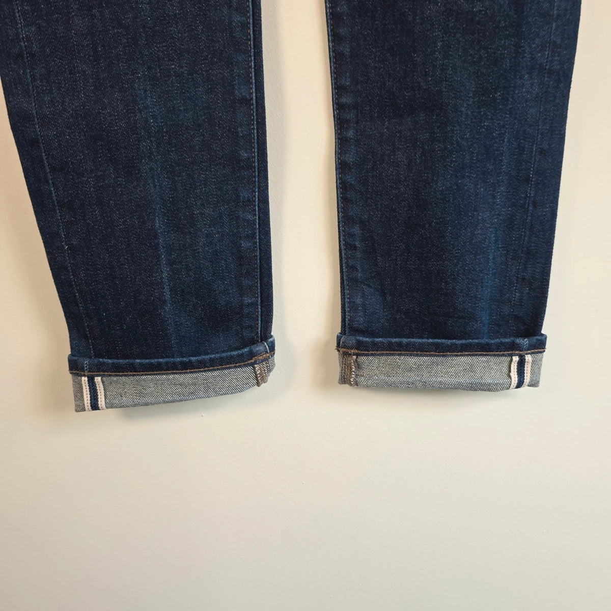 UNIQLO dark indigo slim straight jeans with selvedge detailing and stretch denim material.