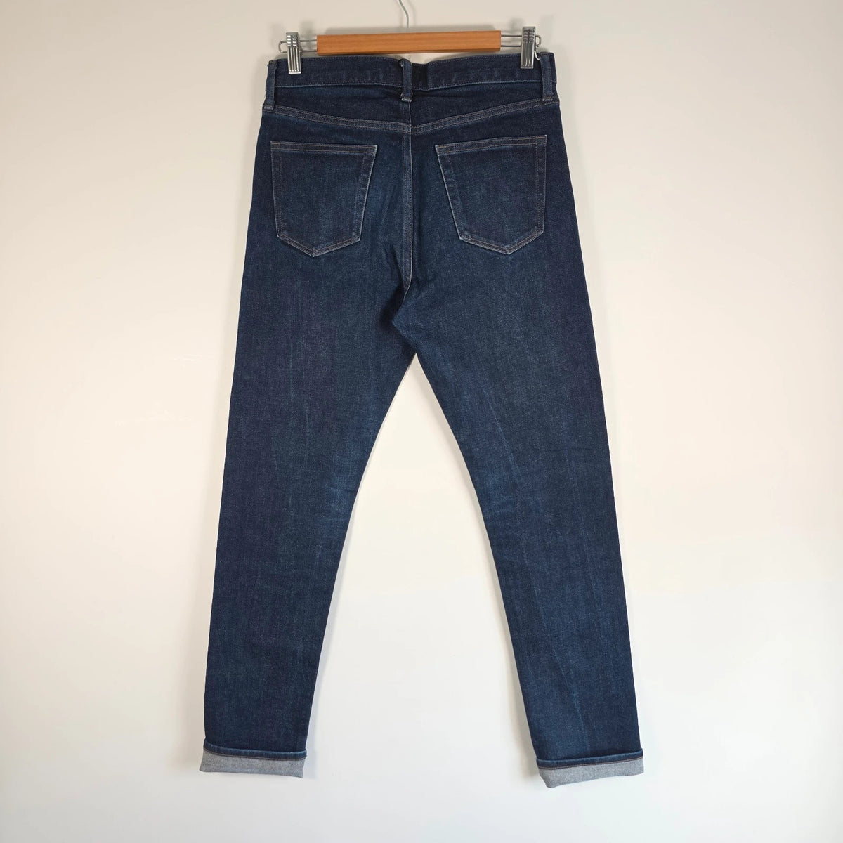 UNIQLO dark indigo slim straight jeans with selvedge detailing and stretch denim material.