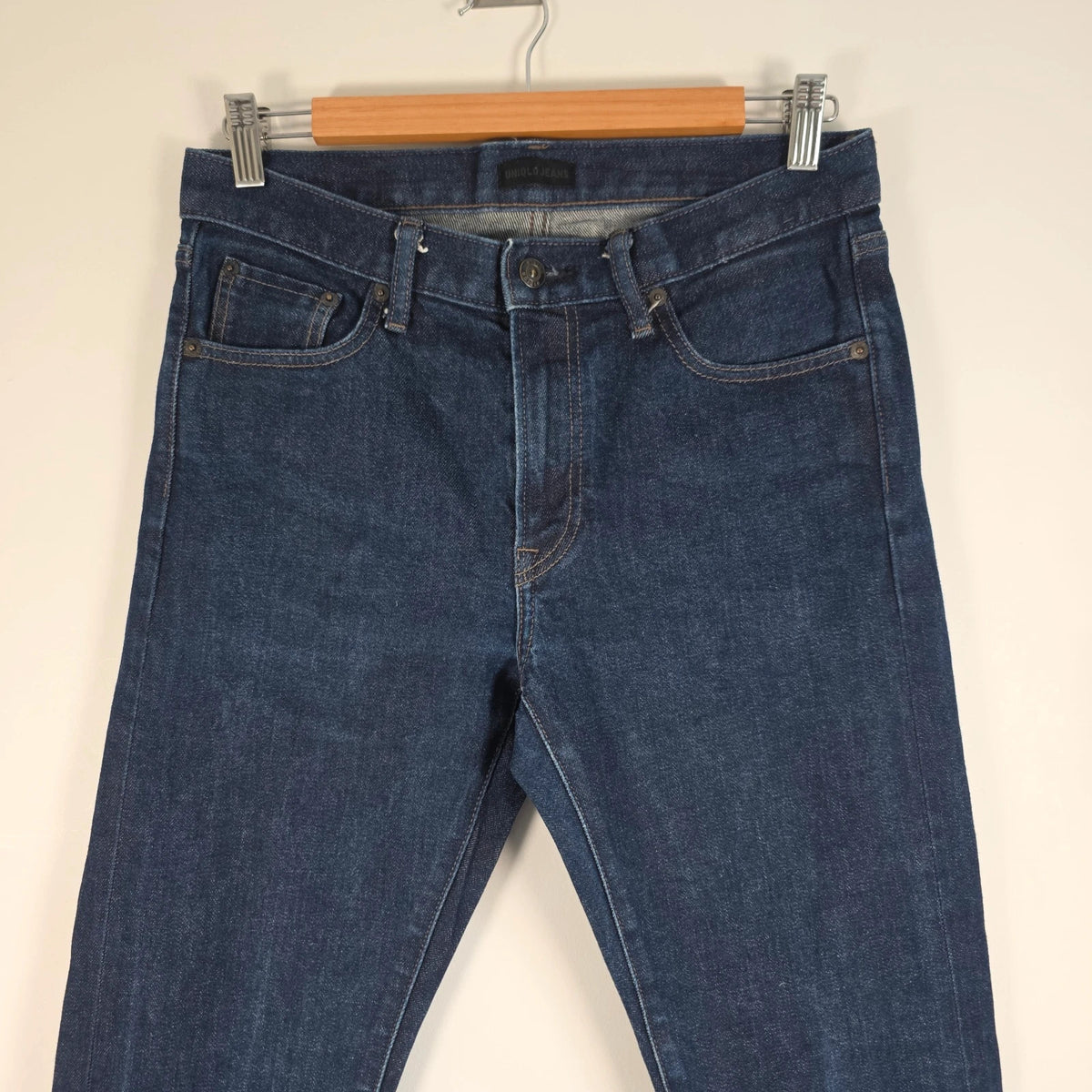 UNIQLO dark indigo slim straight jeans with selvedge detailing and stretch denim material.