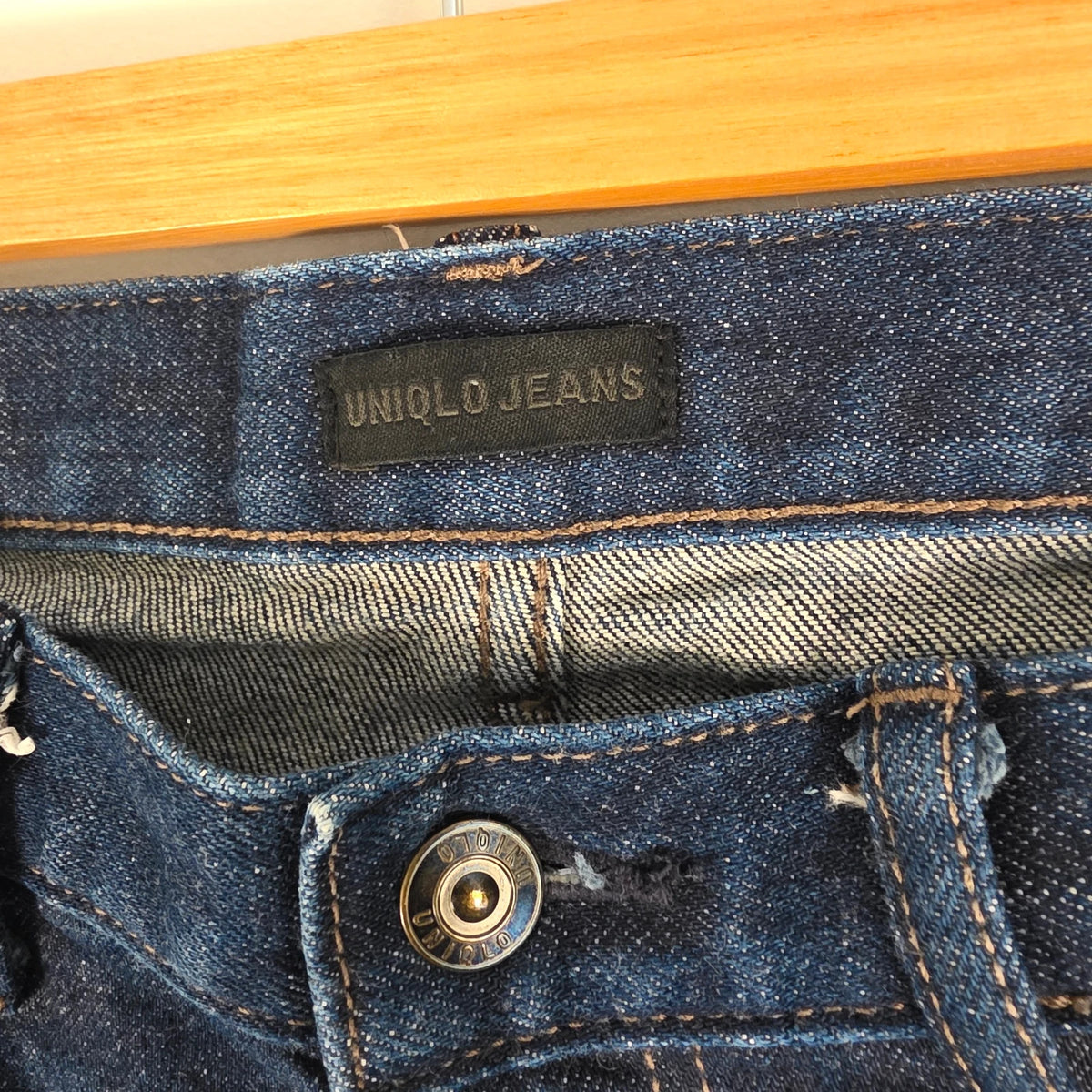 UNIQLO dark indigo slim straight jeans with selvedge detailing and stretch denim material.