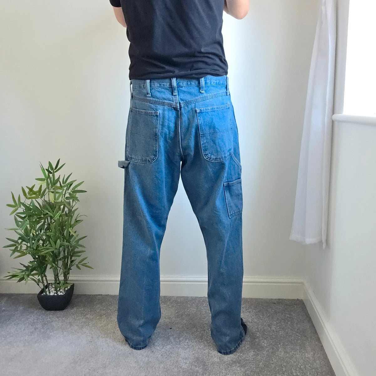Rustler blue carpenter jeans with utility pockets and hammer loop detailing.