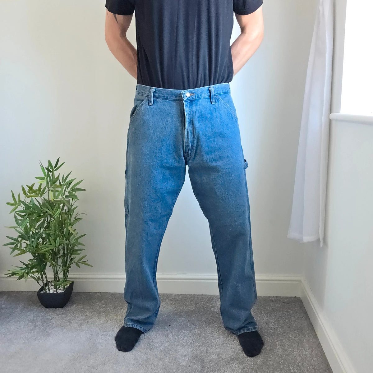 Rustler blue carpenter jeans with utility pockets and hammer loop detailing.