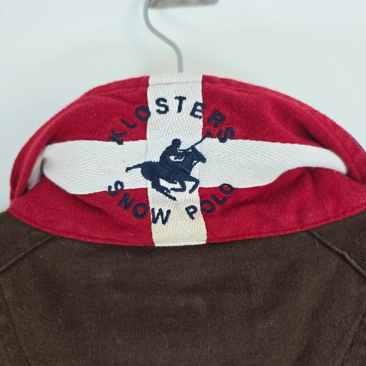 Hackett brown rugby polo shirt with navy collar, embroidered patches, and large back design.
