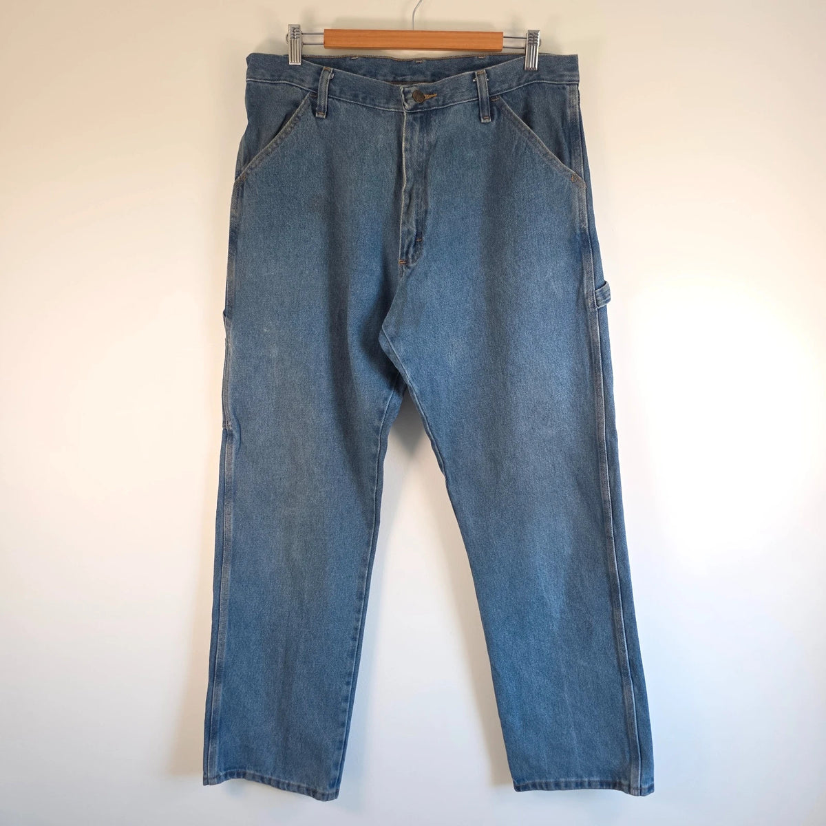 Rustler blue carpenter jeans with utility pockets and hammer loop detailing.