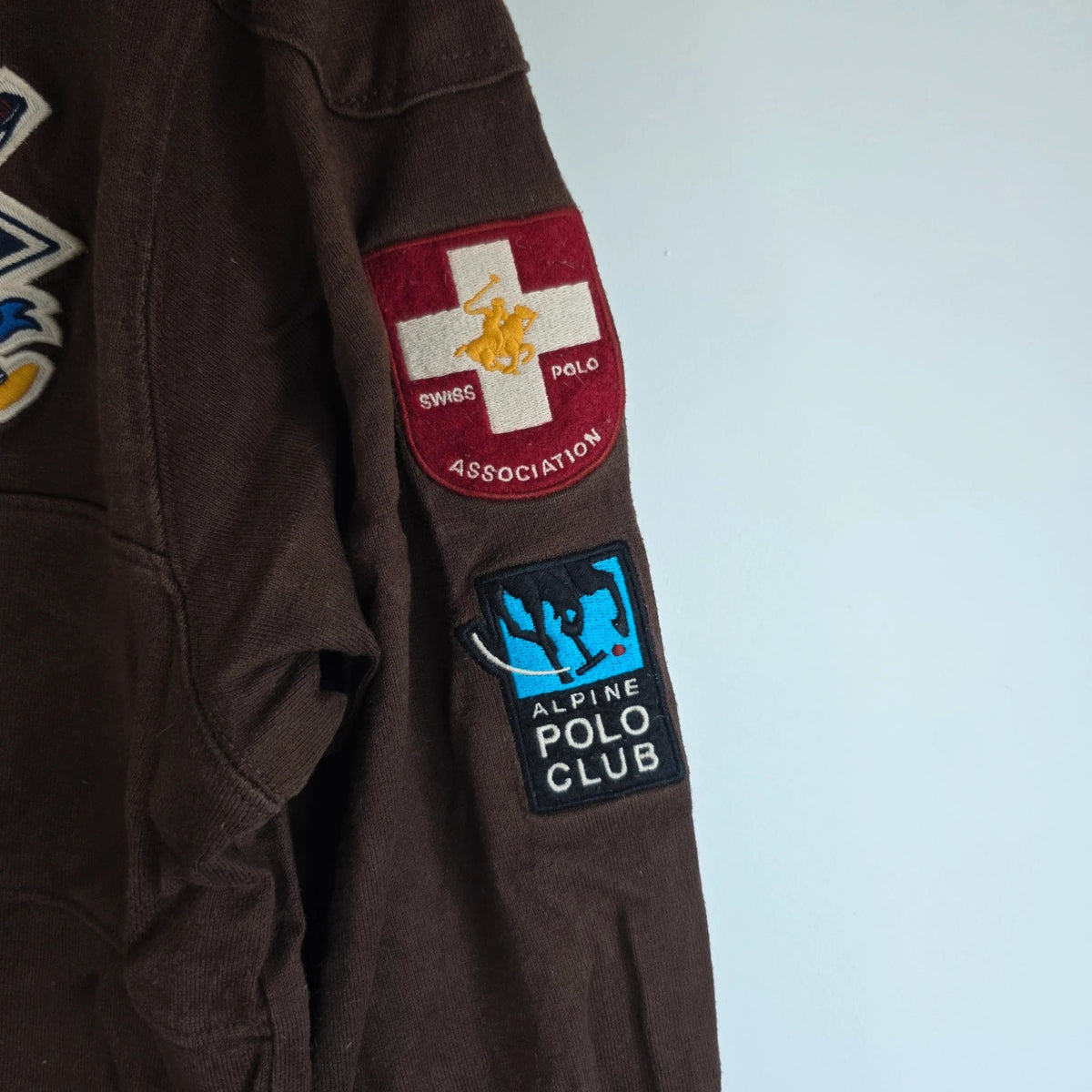 Hackett brown rugby polo shirt with navy collar, embroidered patches, and large back design.