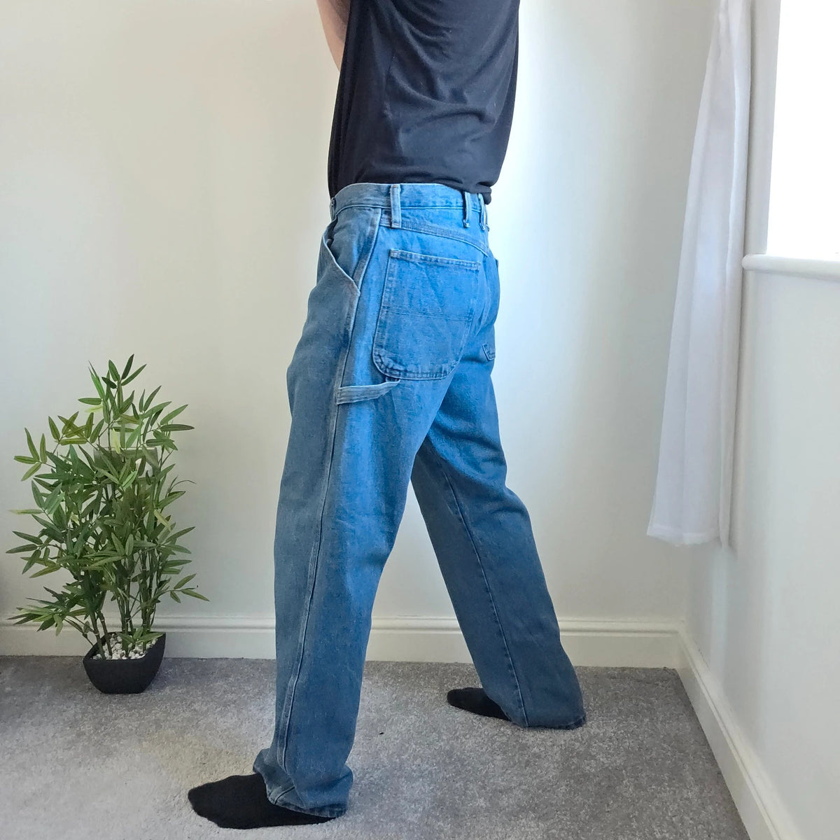 Rustler blue carpenter jeans with utility pockets and hammer loop detailing.