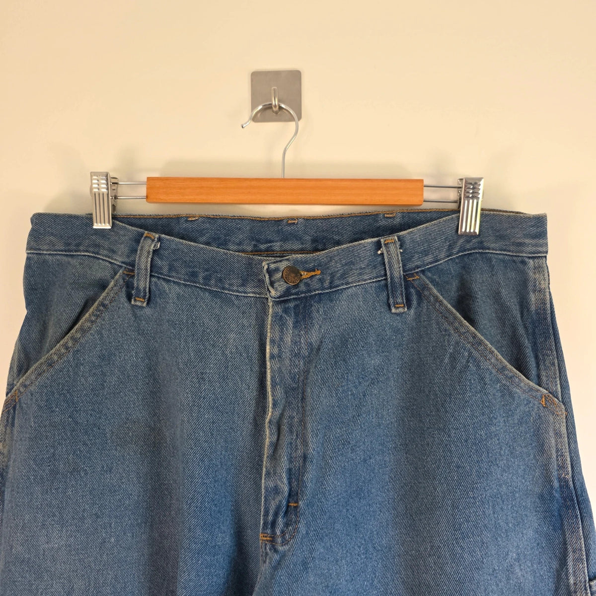 Rustler blue carpenter jeans with utility pockets and hammer loop detailing.
