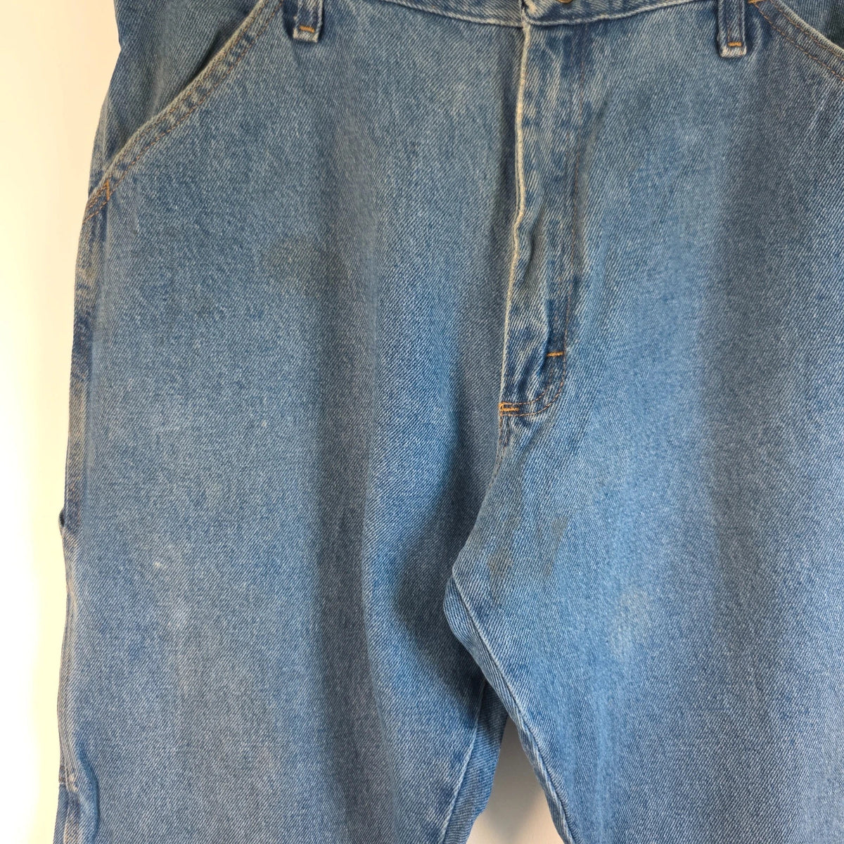 Rustler blue carpenter jeans with utility pockets and hammer loop detailing.