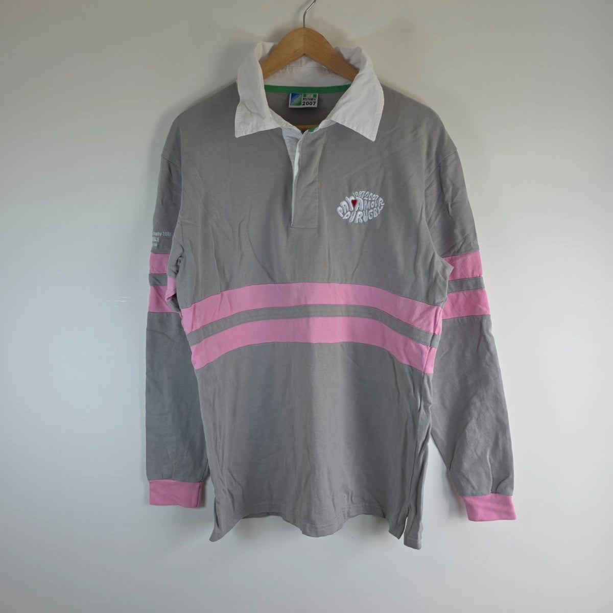 Rugby World Cup grey pink long sleeve polo shirt with IRB logo and Stade de France detail.
