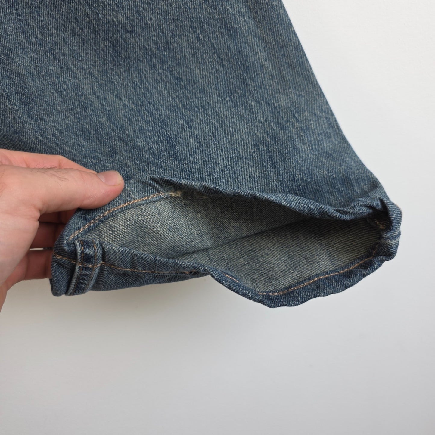 Levi's blue straight leg jeans, cotton material, missing back waist patch, casual style.