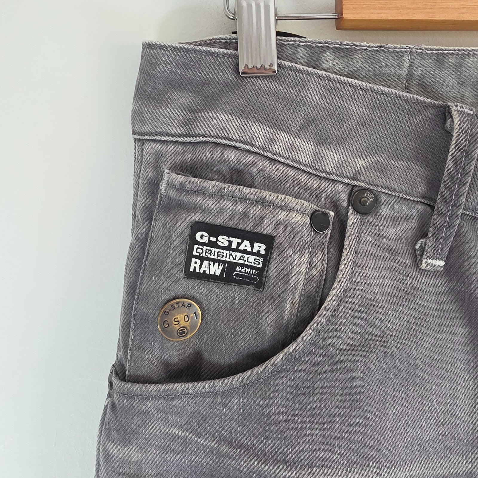 G-Star grey straight jeans with biker style detailing and subtle wear at the hem.