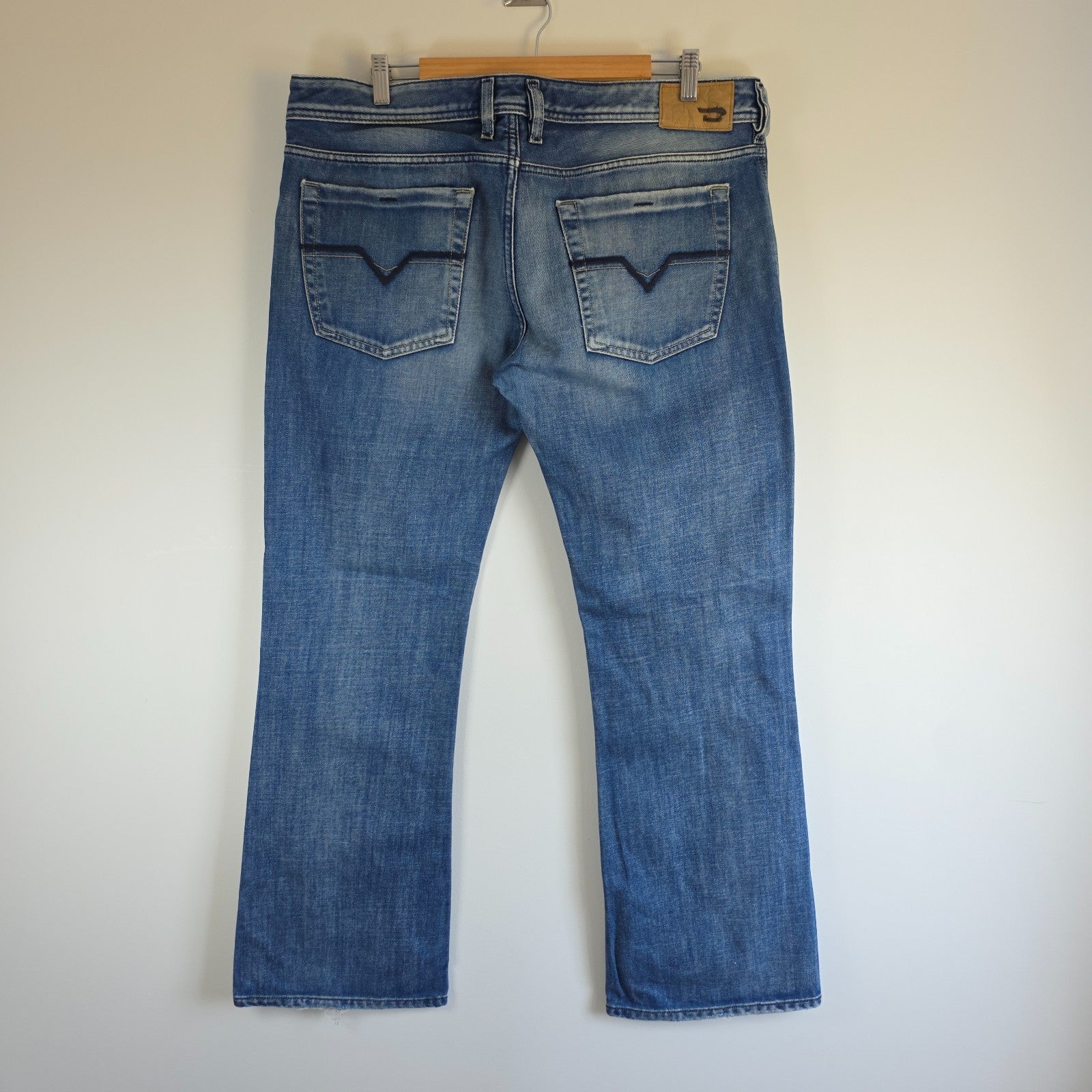 Diesel blue bootcut jeans with button fly and vintage Zathan fit, 100% cotton.