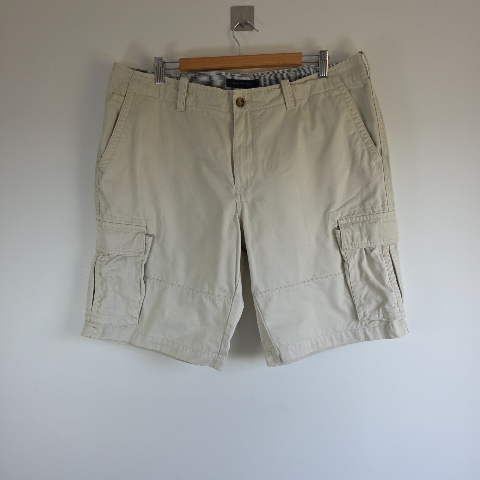 Tommy Hilfiger beige cargo shorts with utility pockets and cotton material.