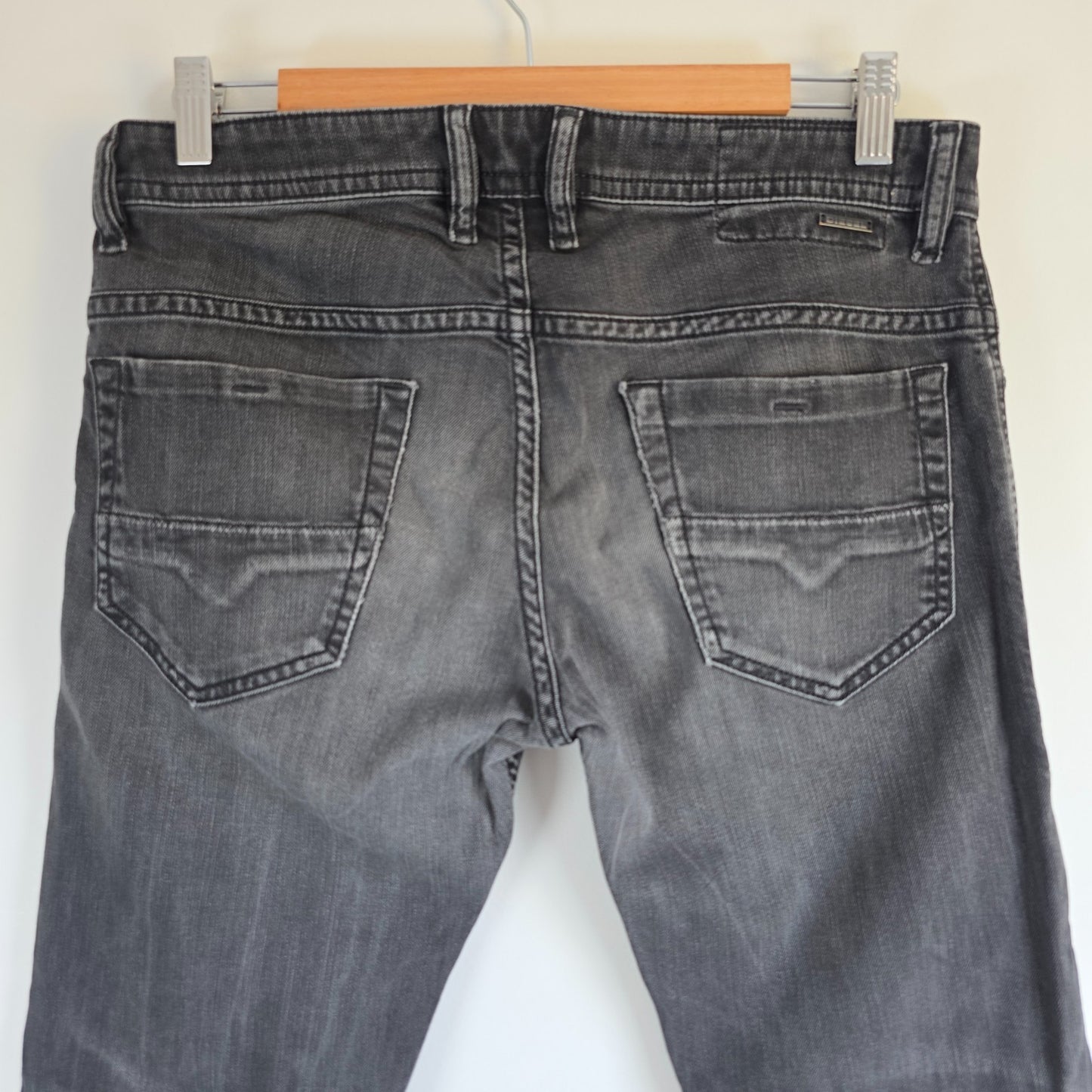 Diesel black straight jeans with grey wash, stretch denim, and branded tag.