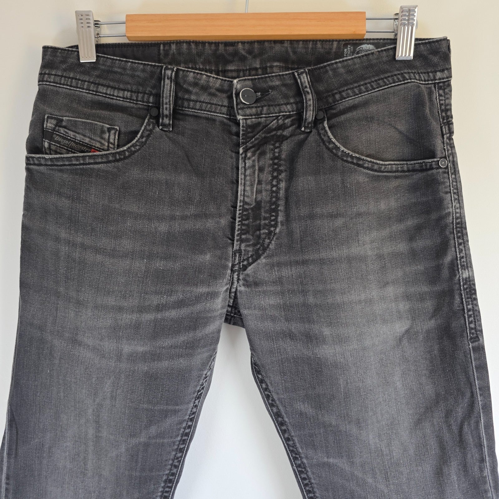 Diesel black straight jeans with grey wash, stretch denim, and branded tag.