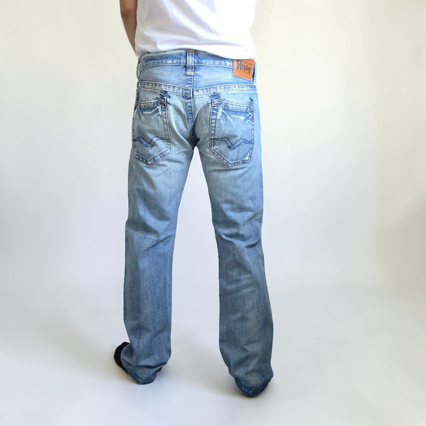 Replay blue straight jeans with button fly and light distressed pocket detailing.