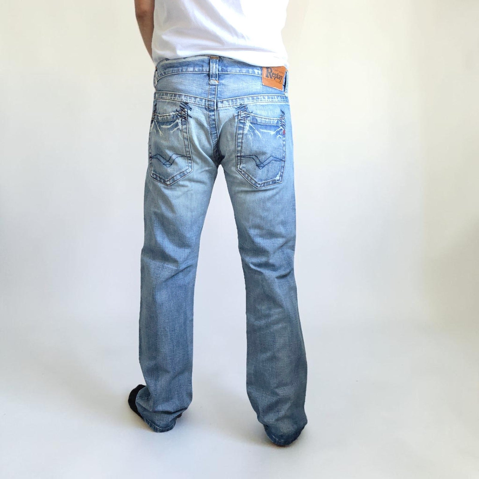 Replay blue straight jeans with button fly and light distressed pocket detailing.