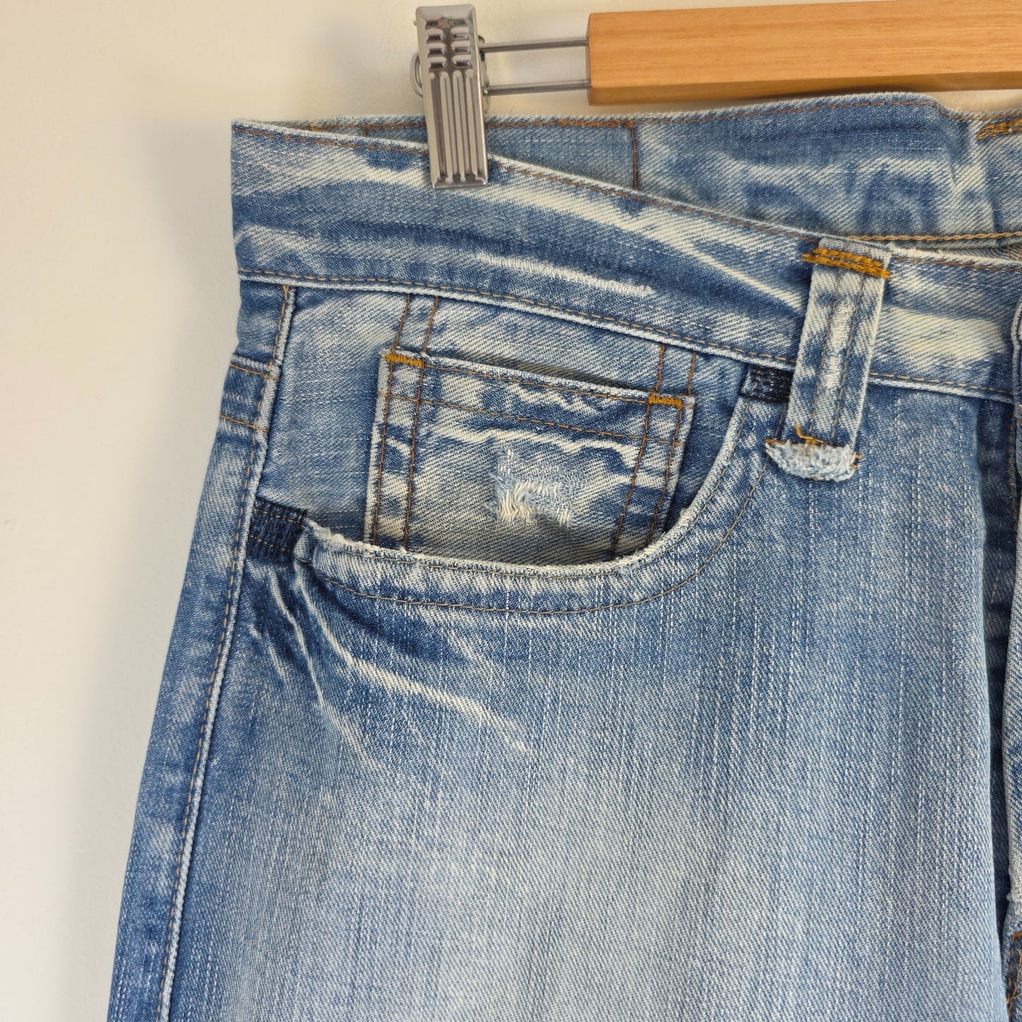Replay blue straight jeans with button fly and light distressed pocket detailing.