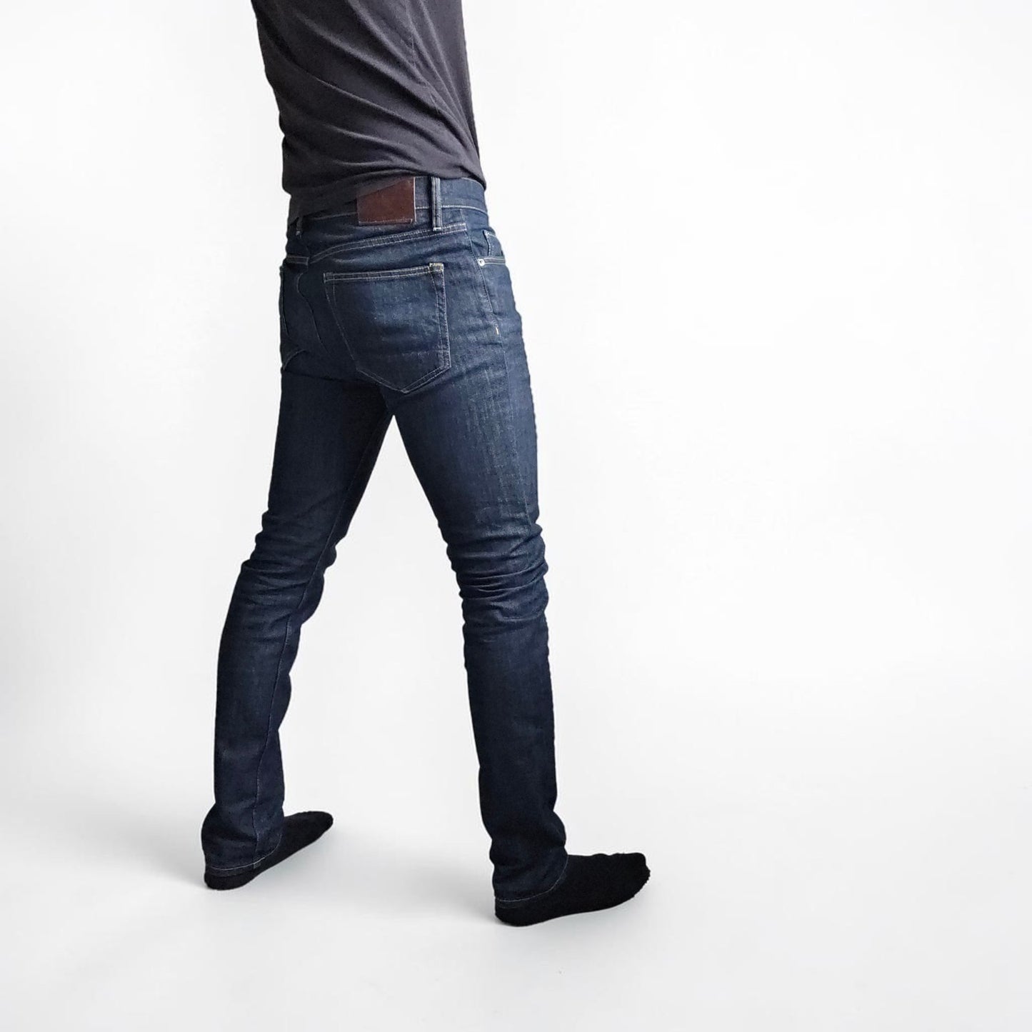 AllSaints blue skinny jeans with button fly and subtle logo detail.