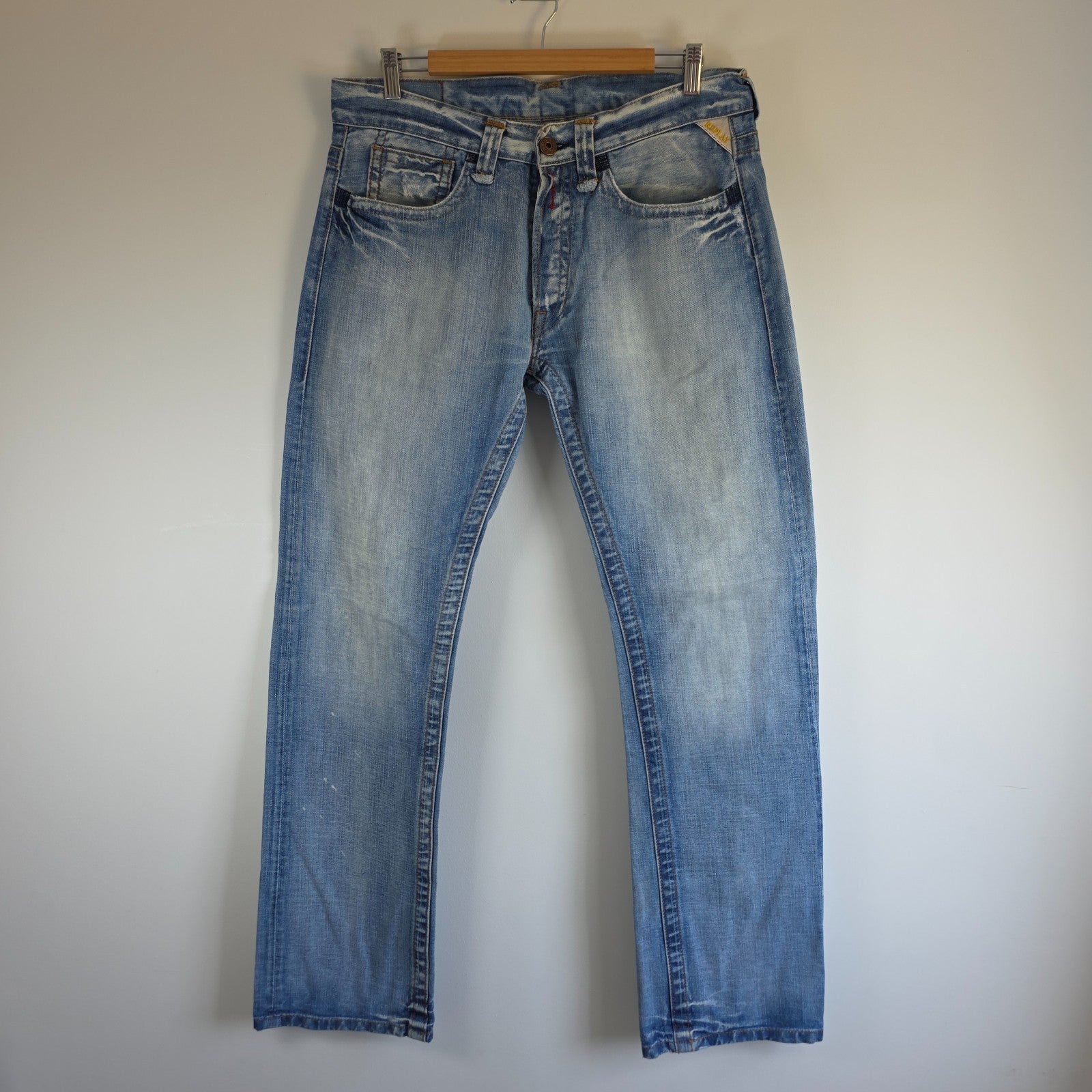 Replay blue straight jeans with button fly and light distressed pocket detailing.