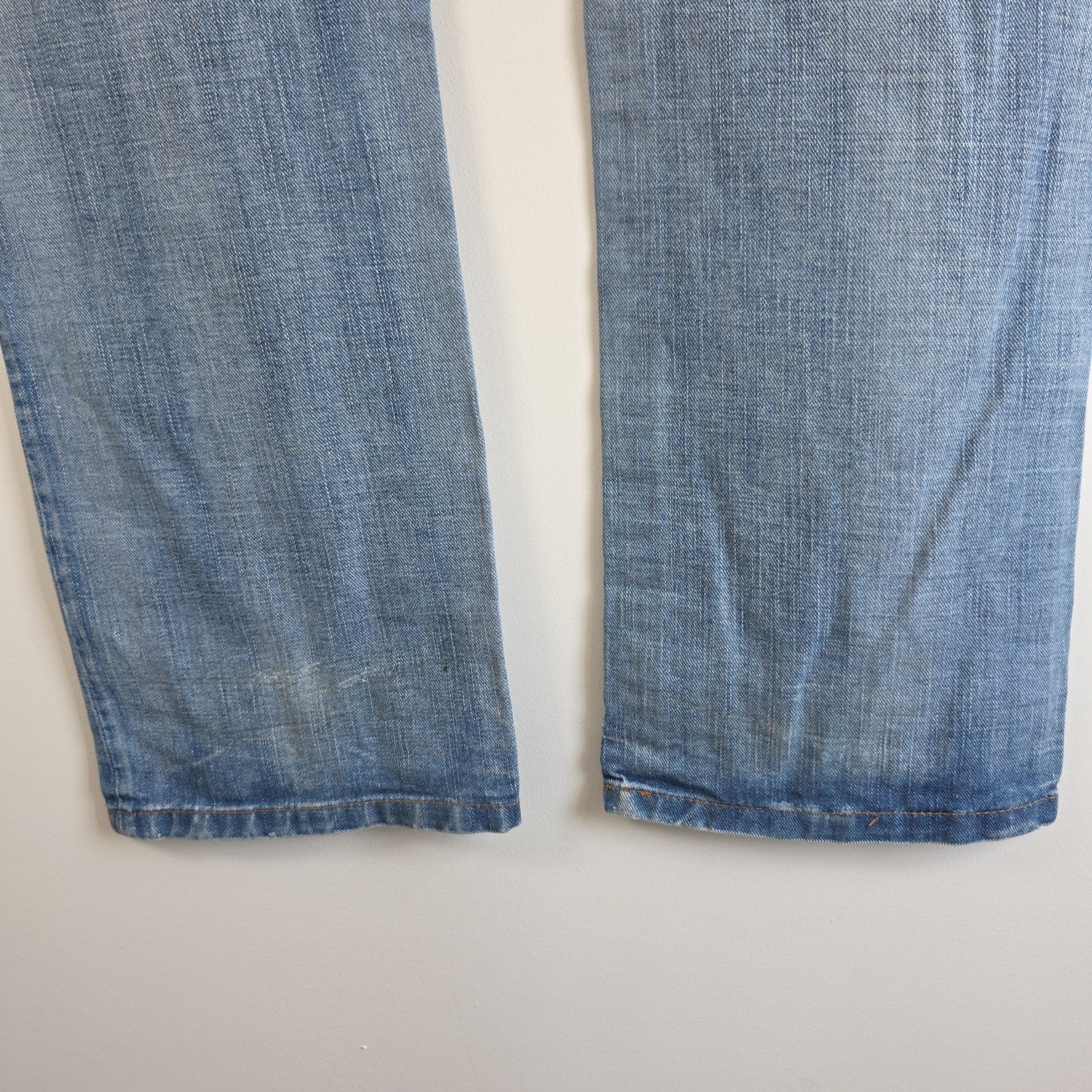 Replay blue straight jeans with button fly and light distressed pocket detailing.