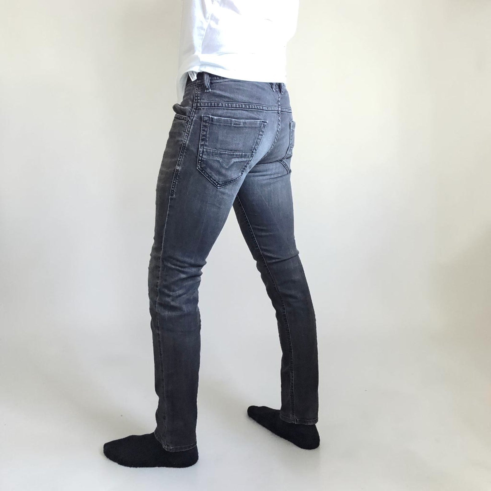 Diesel black straight jeans with grey wash, stretch denim, and branded tag.