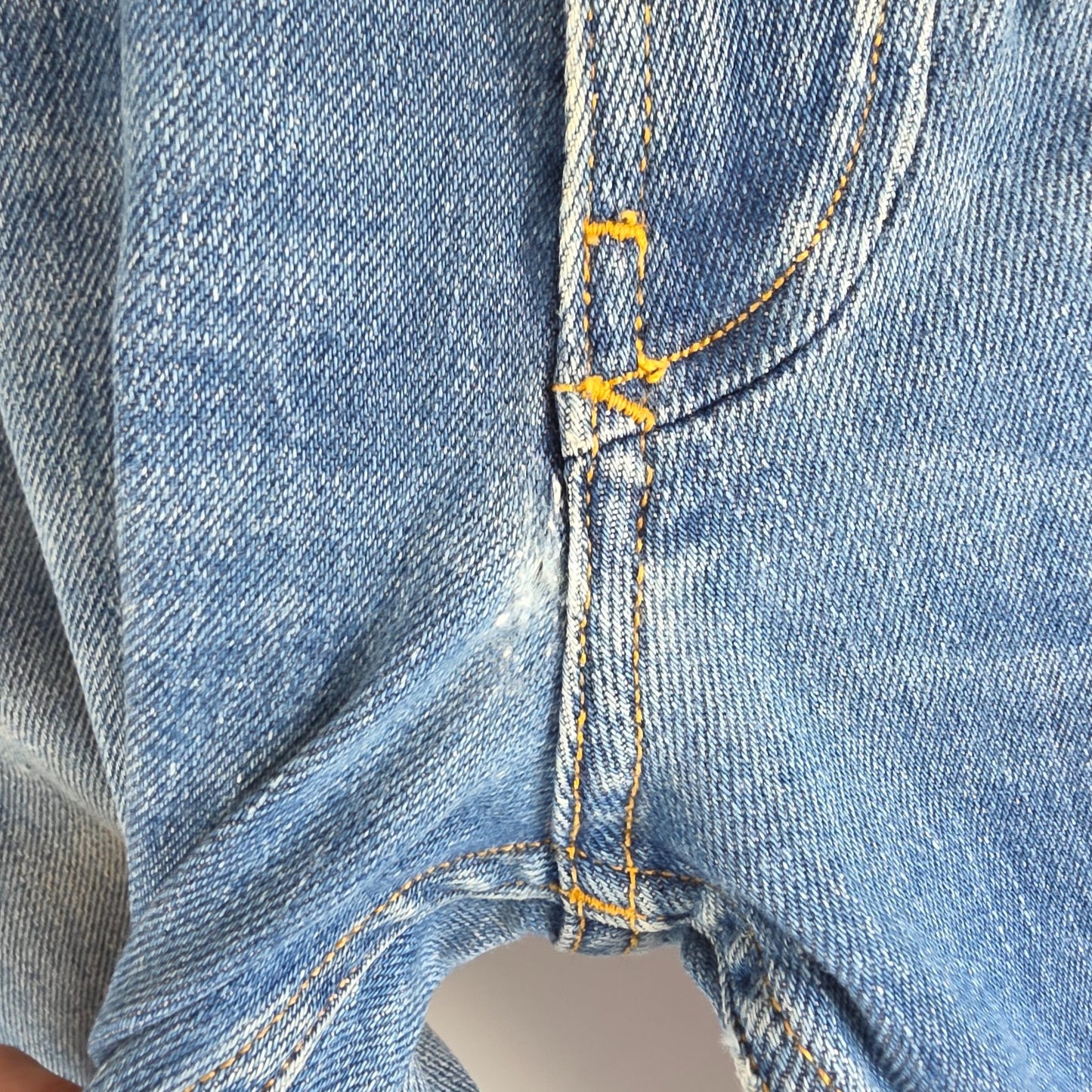 Tommy Hilfiger blue tapered jeans with stretch denim and small rip detail.