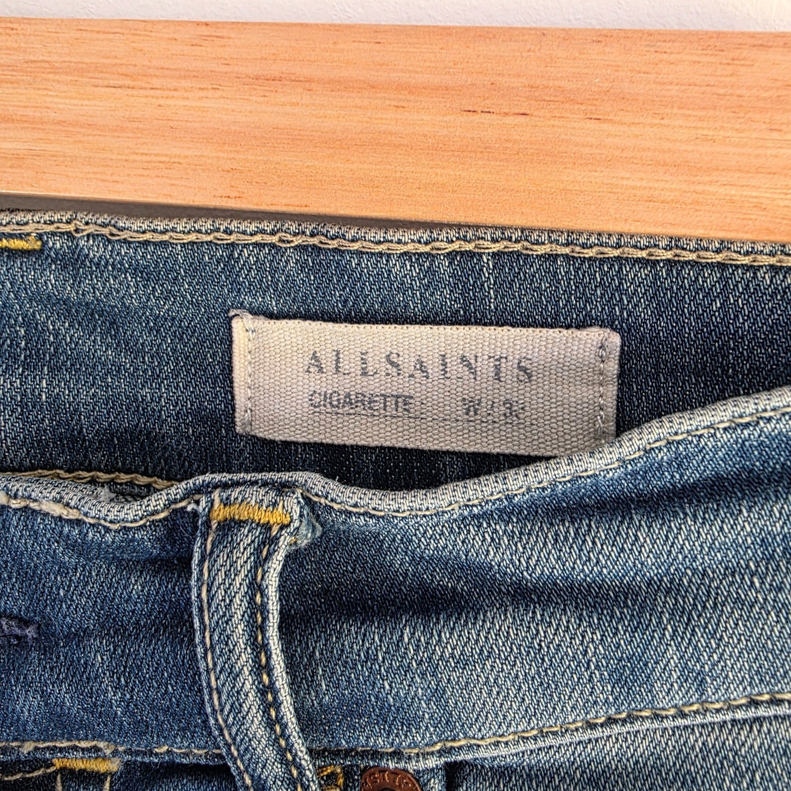 AllSaints blue skinny jeans with faded wash and modern slim fit design.