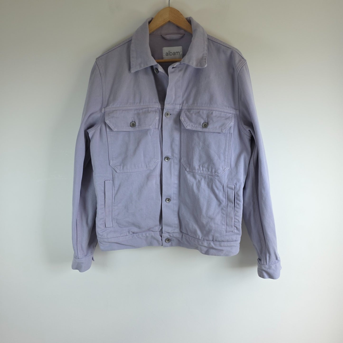 Albam lilac denim jacket with button front, chest pockets, and side pockets.